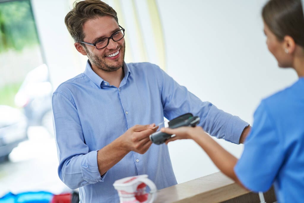 Picture of male patient paying for dental visit in clinic